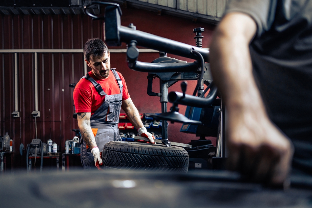 Experienced,Mechanic,Working,On,Tire,Changer,Machine,Removing,Damaged,Tire